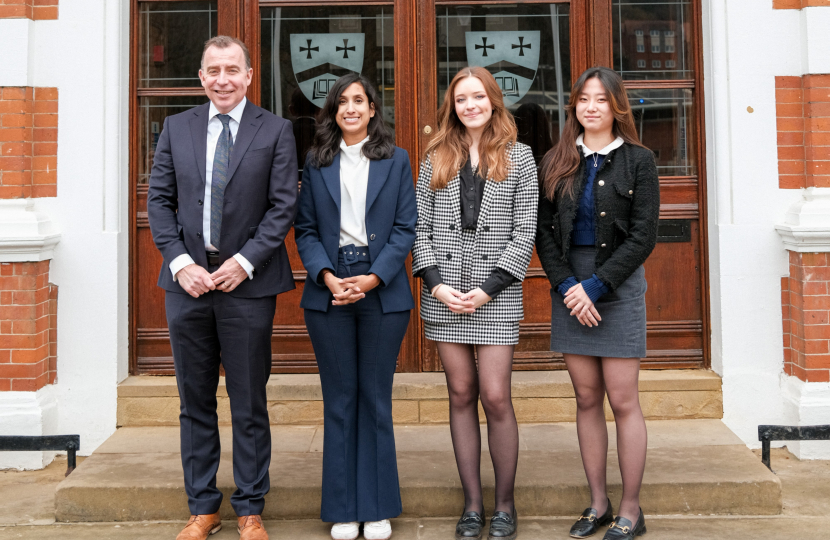 Claire stands outside Caterham School with Mr Jones, Danielle and Paige.