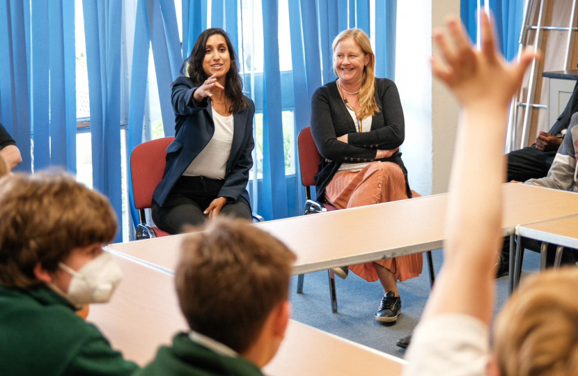 Claire is pointing at a pupil who is raising his hand.