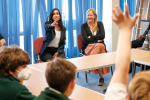 Claire is pointing at a pupil who is raising his hand.