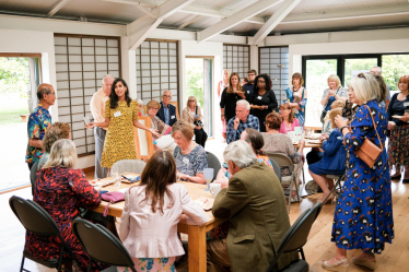 Claire addressing a packed room of members of the Friendship Project