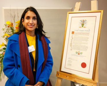 Claire stands with the Coronation Scroll. 