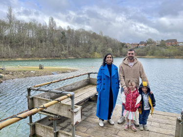 Claire standing on a jetty with Charlie and his children.